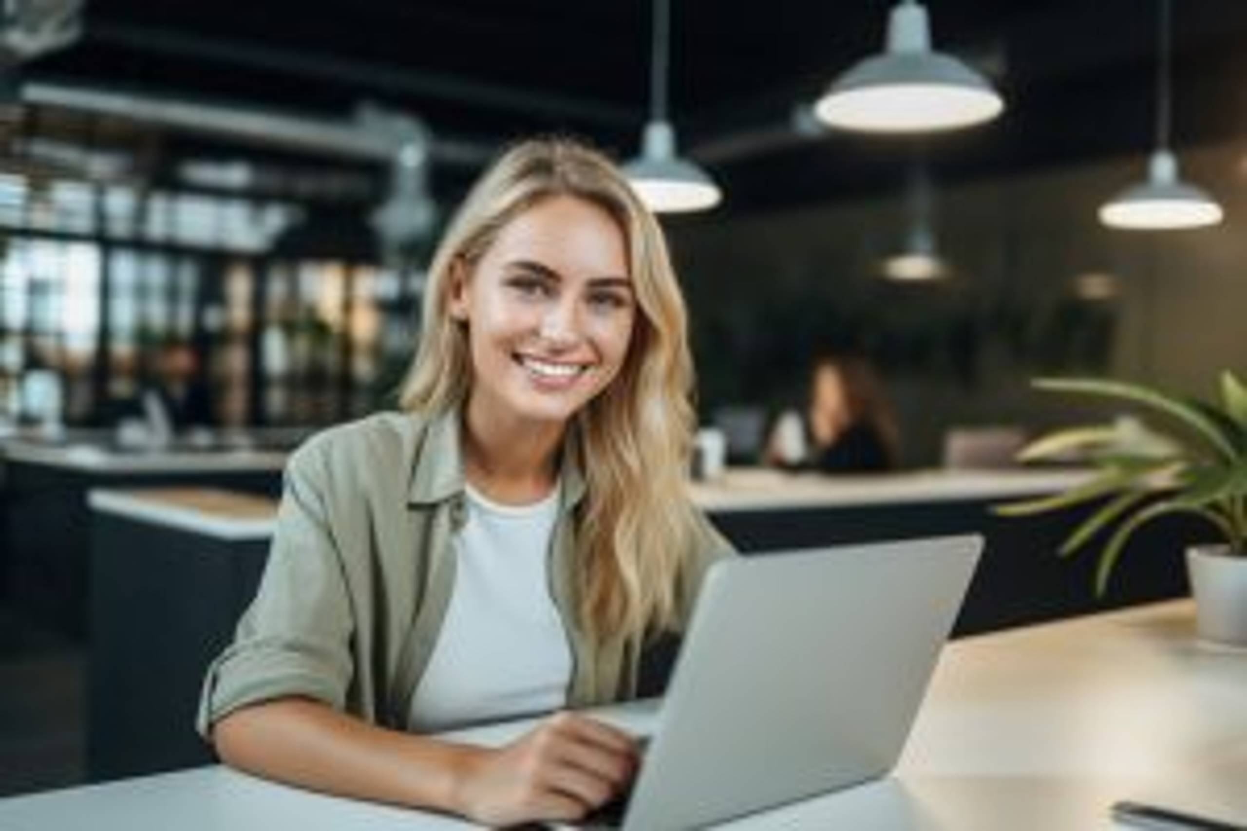happy young woman, smiling girl student using laptop computer sitting on chair in cafe space working online